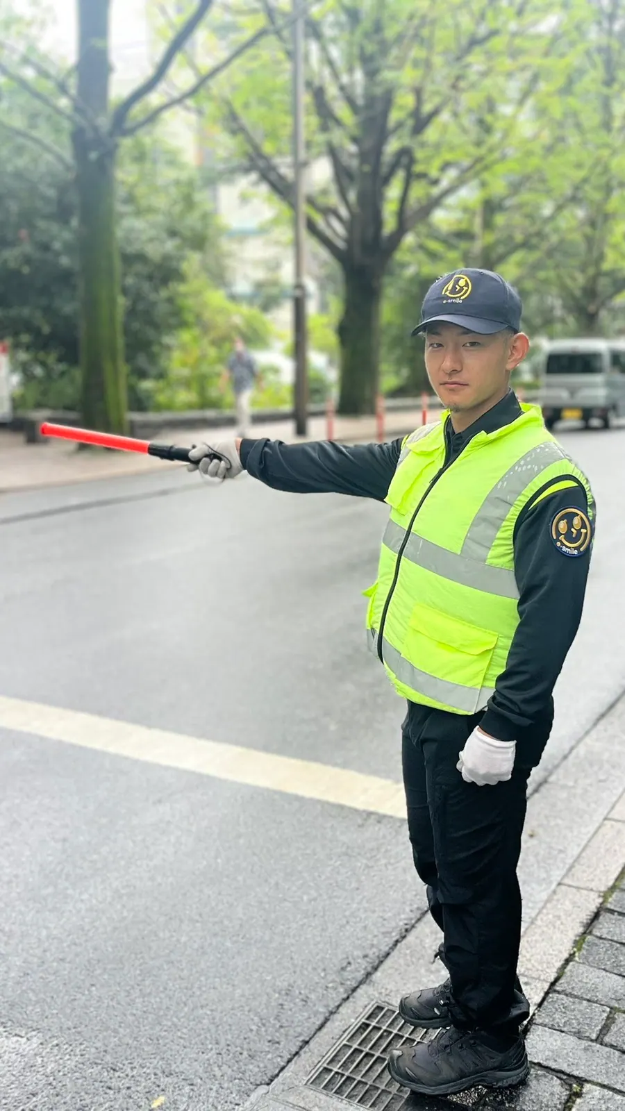 道路で誘導灯を使って合図するイースマイルの警備員